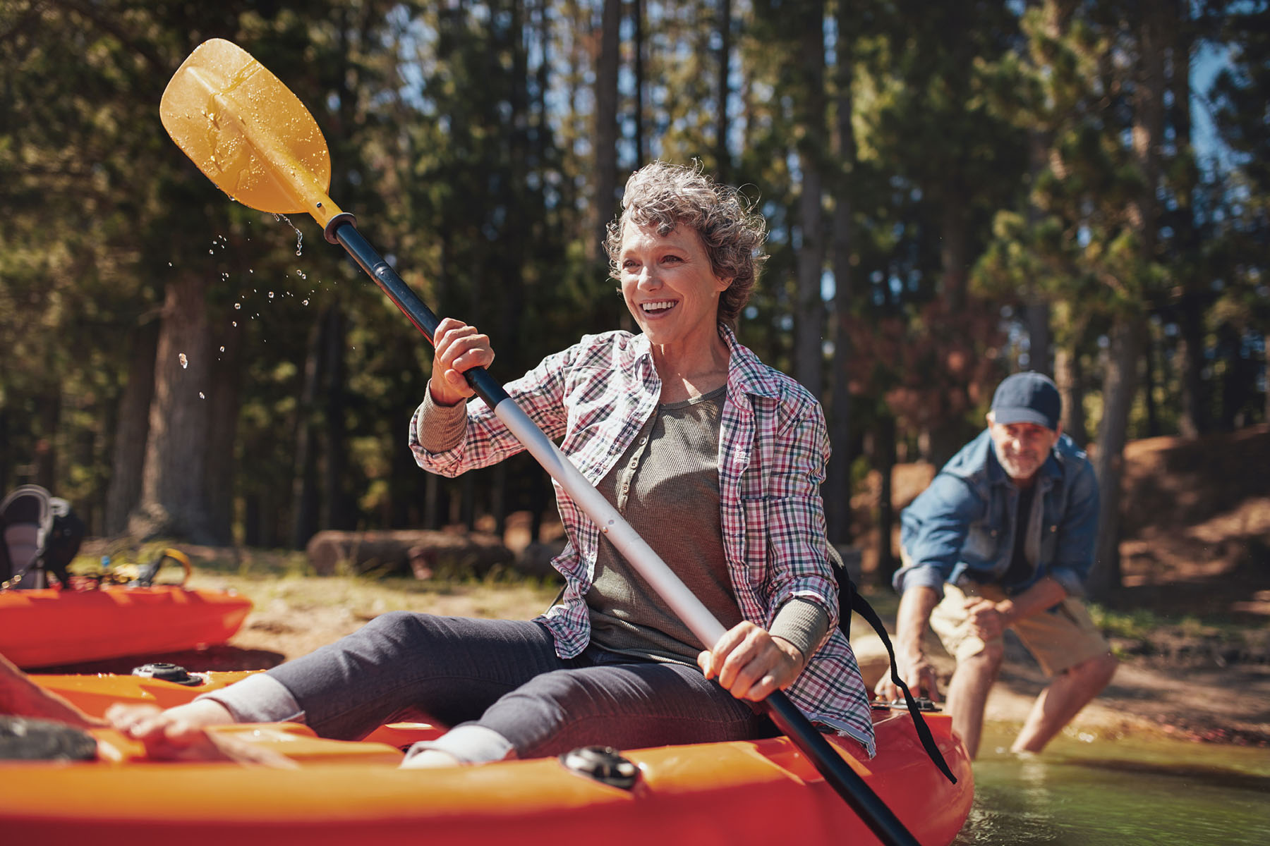 Active senior couple kayaking outdoors representing retirement income planning, healthy retirement lifestyles, long-term financial independence, and retirement wealth preservation strategies