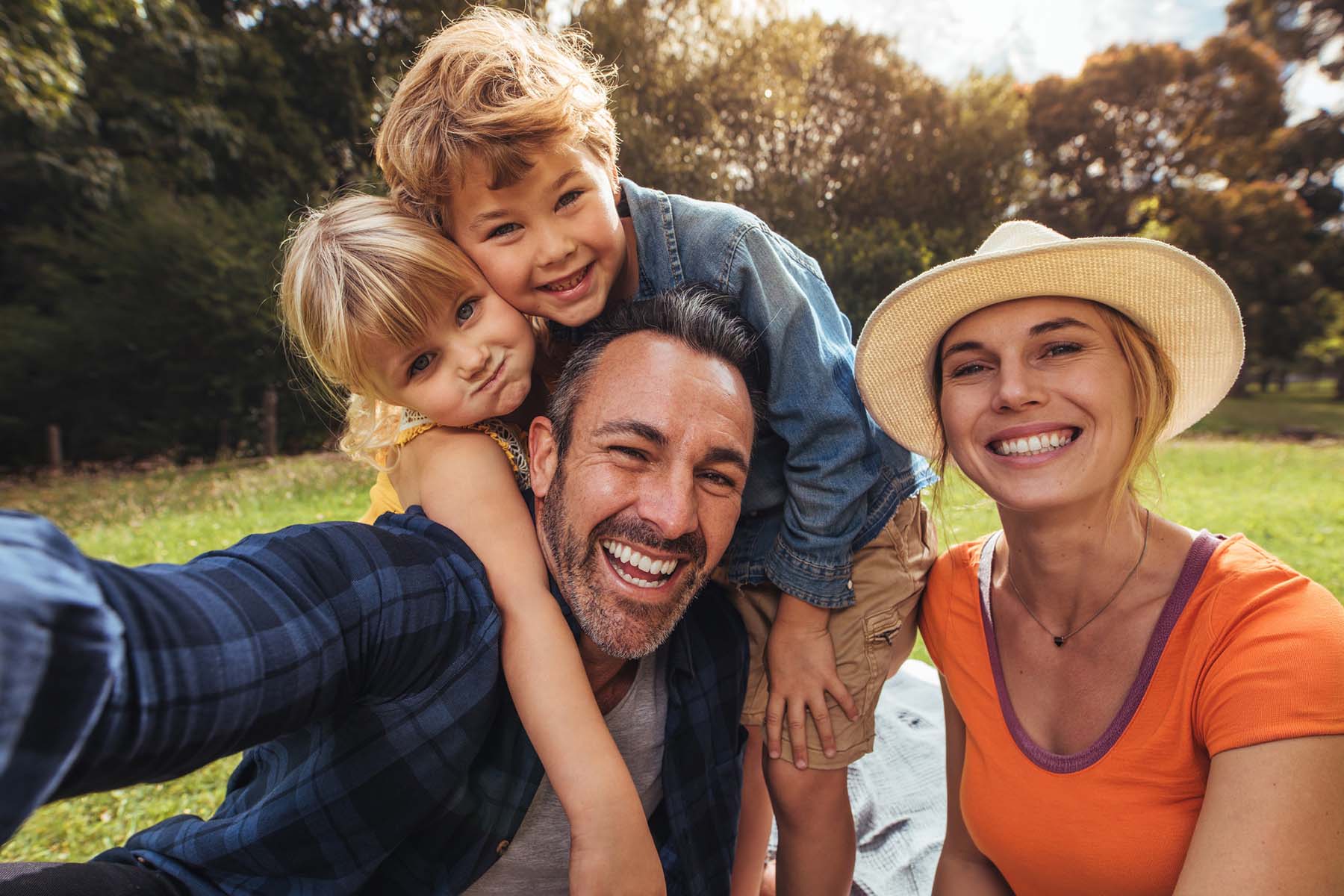Happy family taking outdoor selfie together representing family financial wellness, multigenerational planning, life insurance protection, and future-focused wealth management strategies