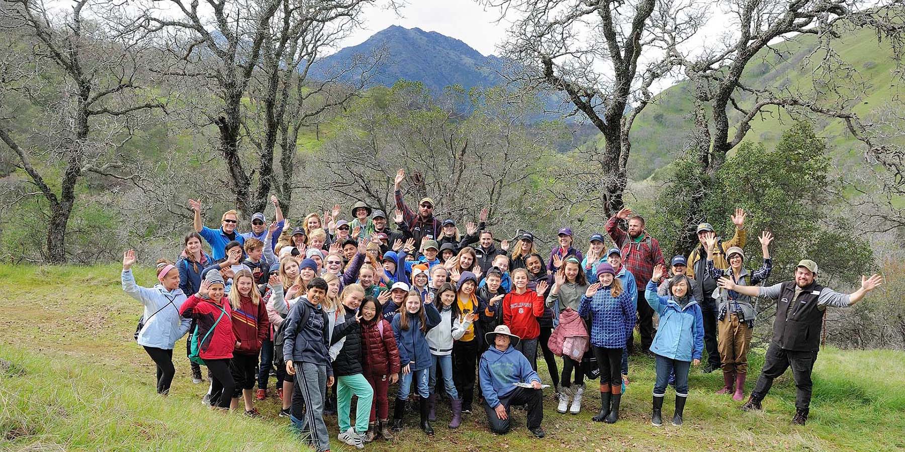 Large outdoor group gathering during a nature outing representing community involvement, volunteer engagement, education programs, and shared outdoor experiences