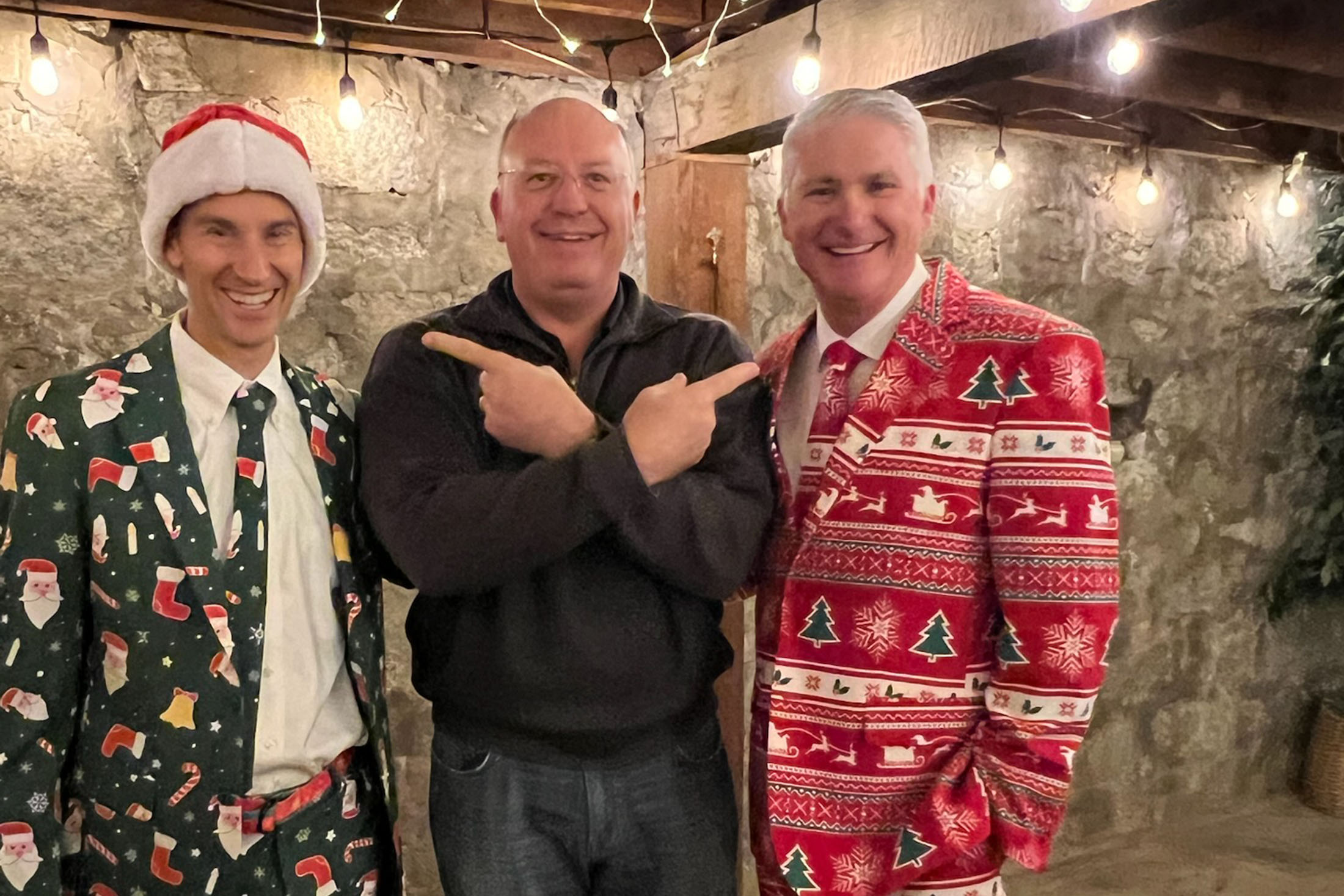 Three colleagues in festive holiday attire at a company celebration representing workplace camaraderie, corporate culture, team appreciation, and end-of-year client or employee events