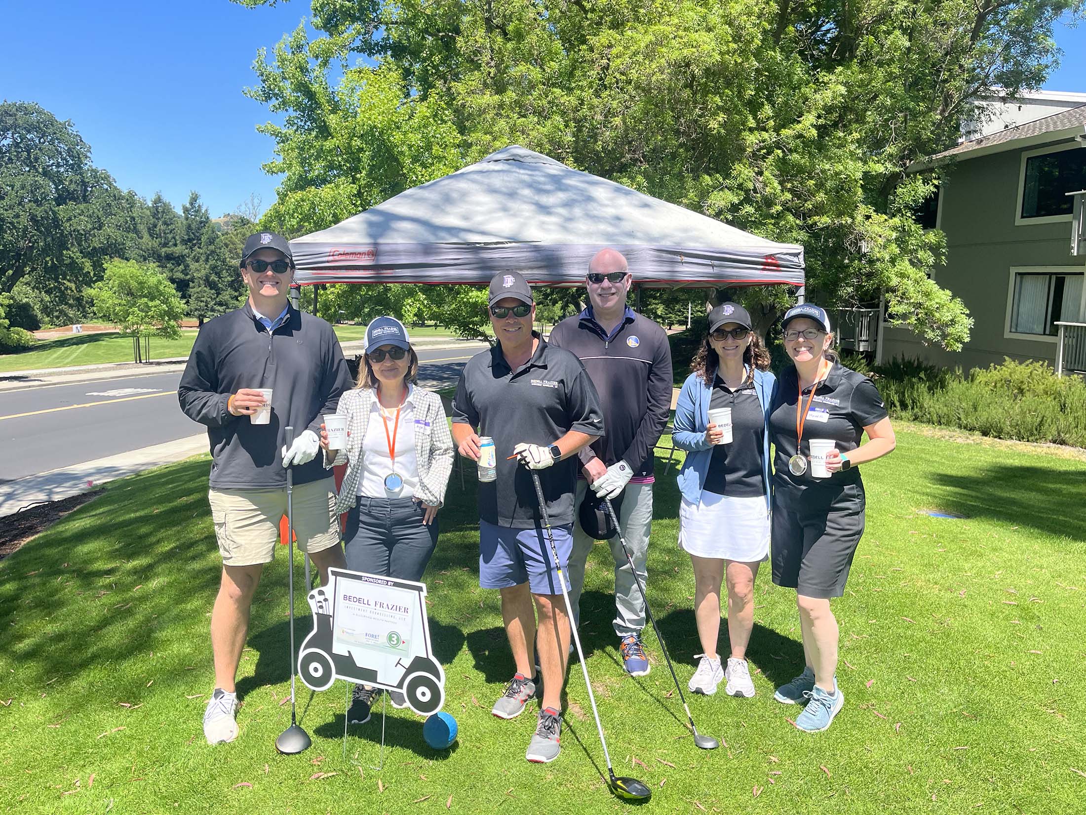 Corporate golf tournament team photo representing business networking, community partnership events, client relationships, and active lifestyle engagement